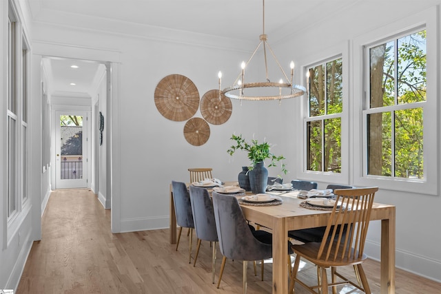 dining area featuring baseboards, a healthy amount of sunlight, and an inviting chandelier