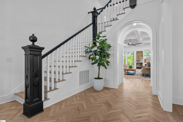 staircase featuring ceiling fan, baseboards, coffered ceiling, and visible vents