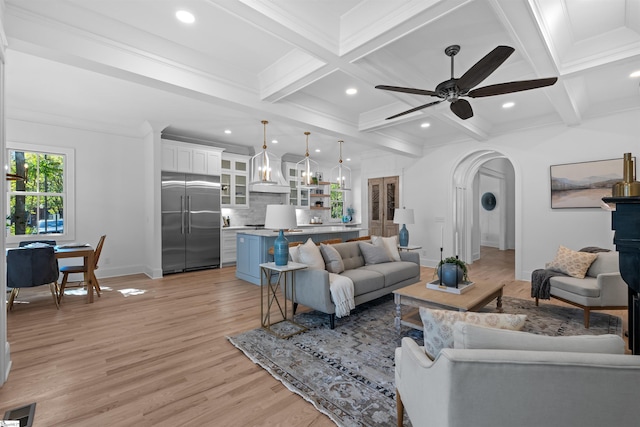 living room with baseboards, visible vents, light wood-style floors, coffered ceiling, and ceiling fan