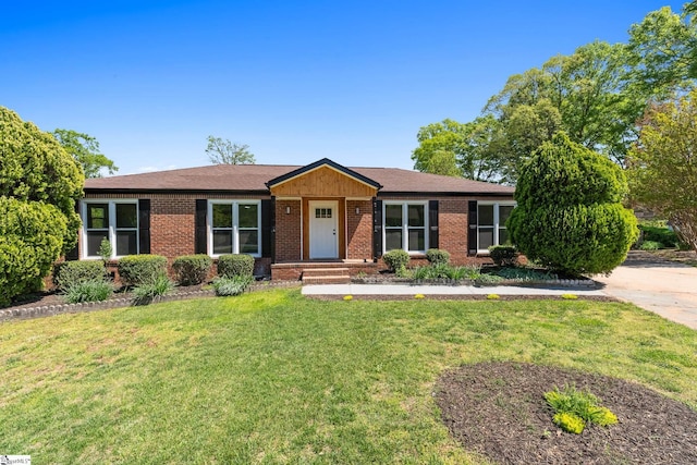 ranch-style house with a front lawn, brick siding, and roof with shingles