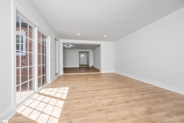 unfurnished room with recessed lighting, wood finished floors, and baseboards