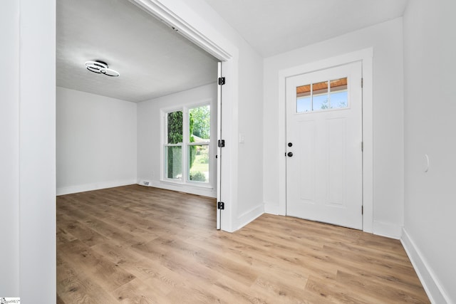 foyer entrance with light wood-type flooring and baseboards