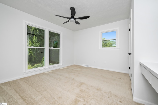 empty room featuring visible vents, carpet flooring, baseboards, and ceiling fan