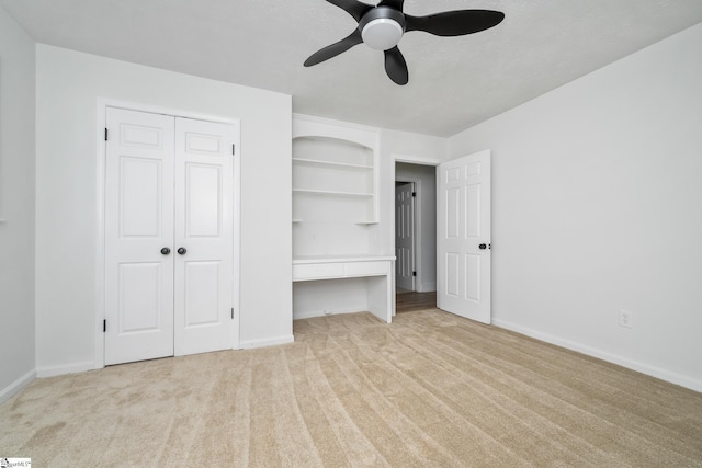 unfurnished bedroom featuring light carpet, baseboards, a closet, and ceiling fan