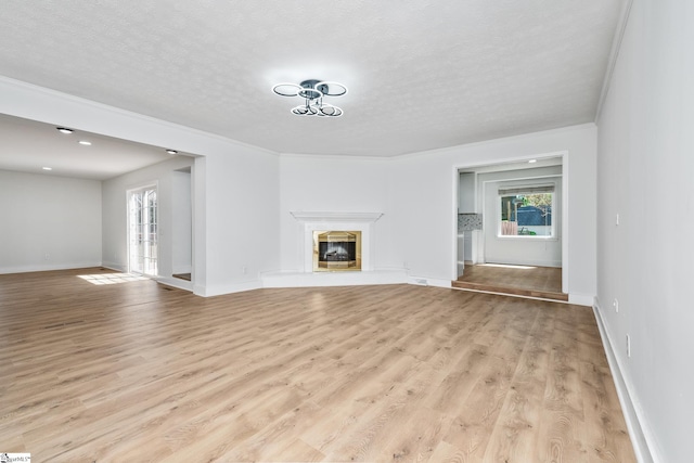 unfurnished living room featuring plenty of natural light, crown molding, and light wood-type flooring
