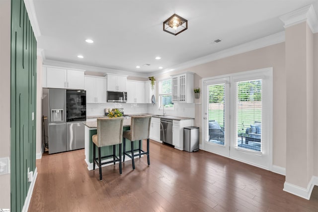204 Lambert Ct, Simpsonville, SC 29680 - kitchen with stainless steel appliances, a center island, a kitchen breakfast bar, visible vents, and ornamental molding