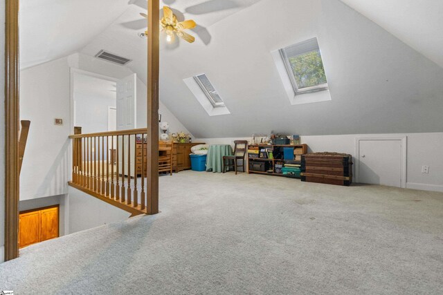 additional living space with ceiling fan, visible vents, carpet flooring, and vaulted ceiling with skylight