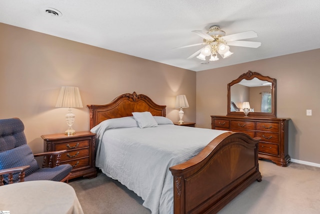 bedroom featuring ceiling fan, baseboards, visible vents, and light colored carpet