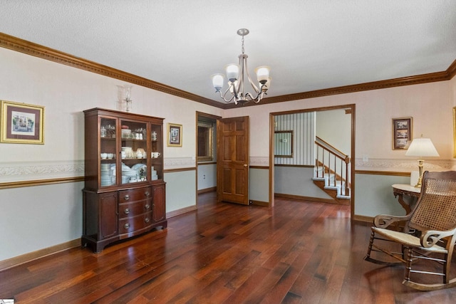 sitting room with dark wood-style floors, baseboards, a notable chandelier, stairs, and crown molding
