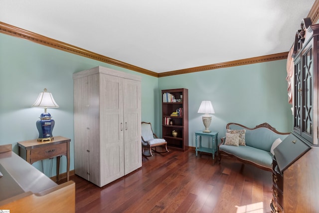 sitting room with baseboards, crown molding, and dark wood-style floors