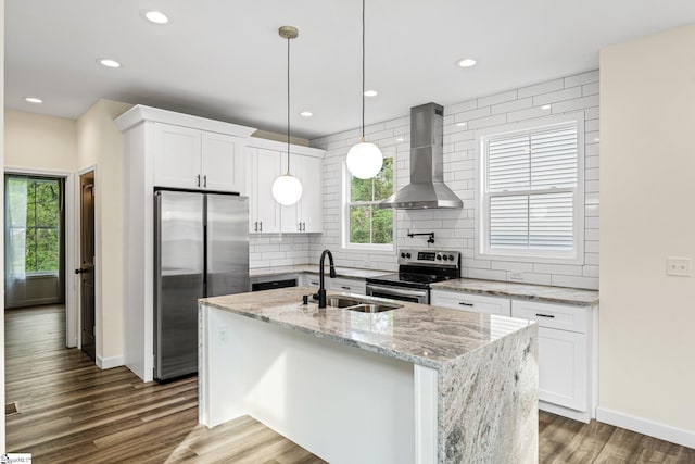 kitchen featuring backsplash, a sink, wall chimney exhaust hood, baseboards, and appliances with stainless steel finishes