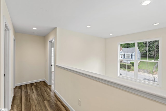 hall featuring dark wood finished floors, baseboards, and recessed lighting