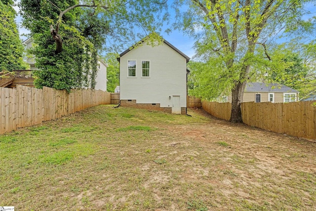 back of house with a fenced backyard, crawl space, and a lawn