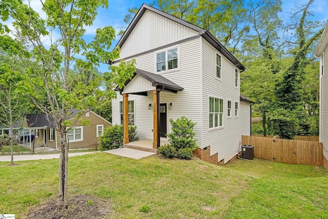 traditional-style home with fence, cooling unit, and a front yard