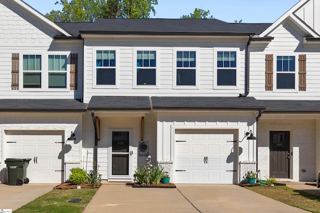 multi unit property featuring concrete driveway and a garage