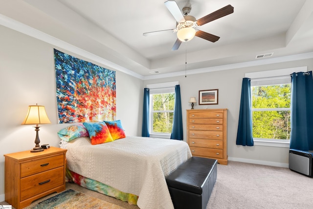 carpeted bedroom featuring visible vents, ceiling fan, baseboards, and a raised ceiling