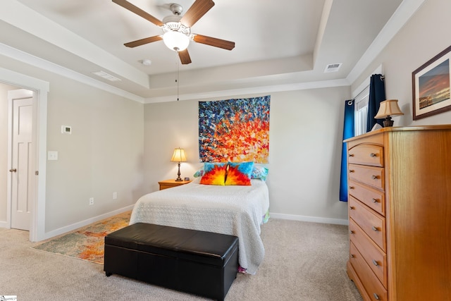 bedroom featuring visible vents, a tray ceiling, and light colored carpet