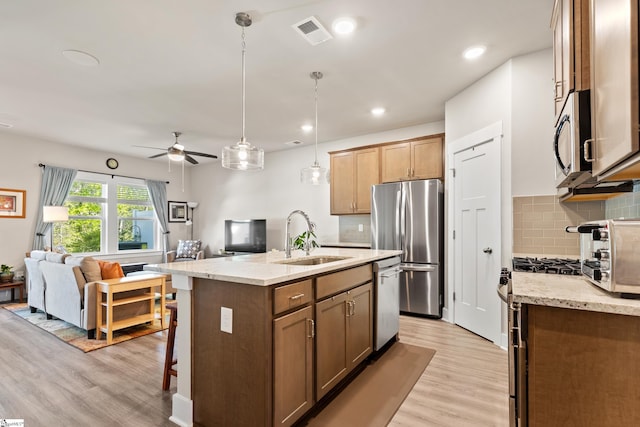 kitchen with open floor plan, visible vents, a sink, and appliances with stainless steel finishes