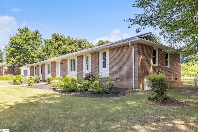 view of front of property with brick siding, a front lawn, and fence