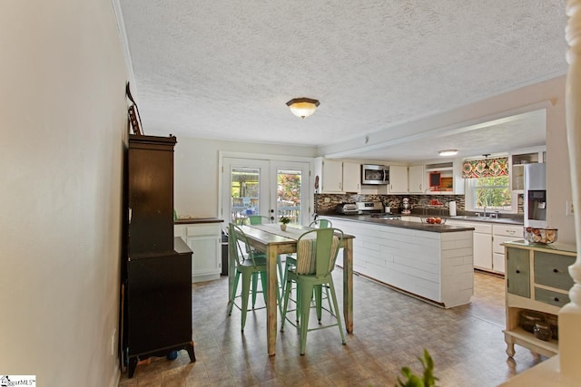 dining space featuring a textured ceiling and light floors