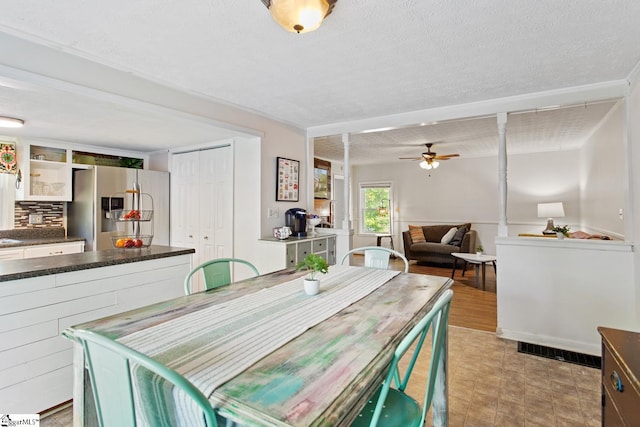 dining space with ceiling fan and a textured ceiling