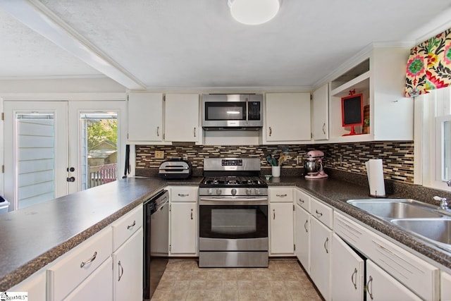 kitchen with white cabinets, dark countertops, tasteful backsplash, and stainless steel appliances