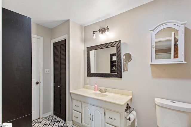 bathroom with a closet, toilet, and vanity