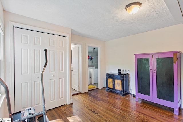 interior space featuring wood finished floors, a textured ceiling, and washer and clothes dryer