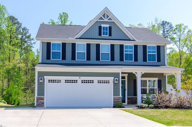 craftsman-style home featuring a garage, driveway, stone siding, and covered porch