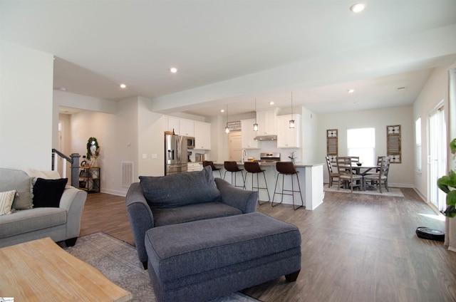 living room with baseboards, recessed lighting, and dark wood finished floors