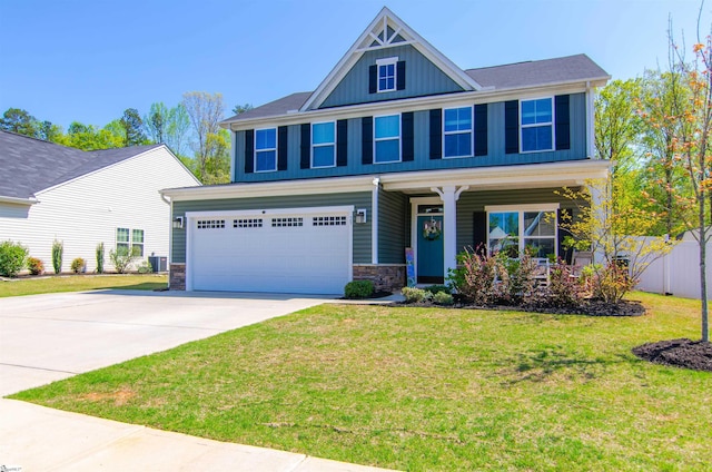 craftsman-style home featuring stone siding, a porch, concrete driveway, an attached garage, and a front yard