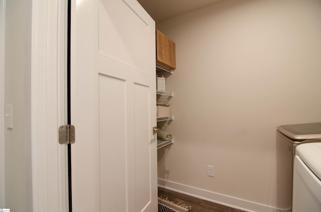 laundry area with dark wood finished floors, separate washer and dryer, baseboards, and laundry area