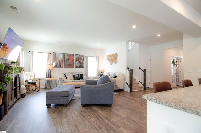 living room with light wood-style floors, a healthy amount of sunlight, stairs, and visible vents
