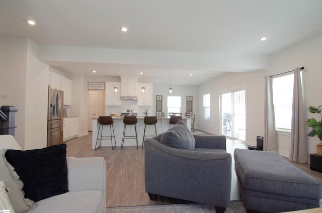 living area with recessed lighting and light wood-style floors