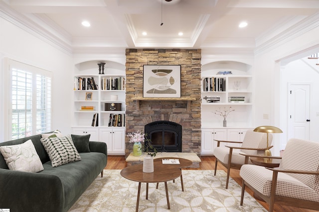 living room featuring built in shelves, beamed ceiling, a fireplace, coffered ceiling, and ornamental molding