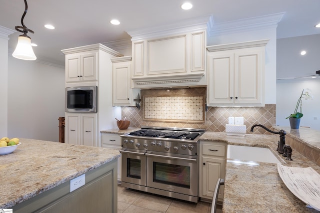 kitchen featuring appliances with stainless steel finishes, tasteful backsplash, a sink, and custom range hood