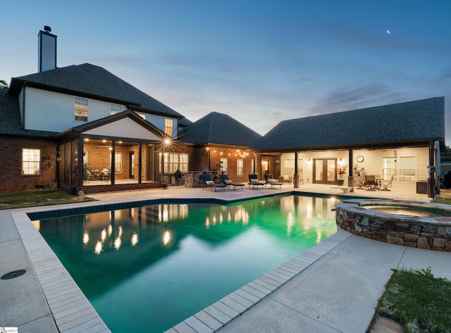 view of pool with a patio, a pool with connected hot tub, and french doors