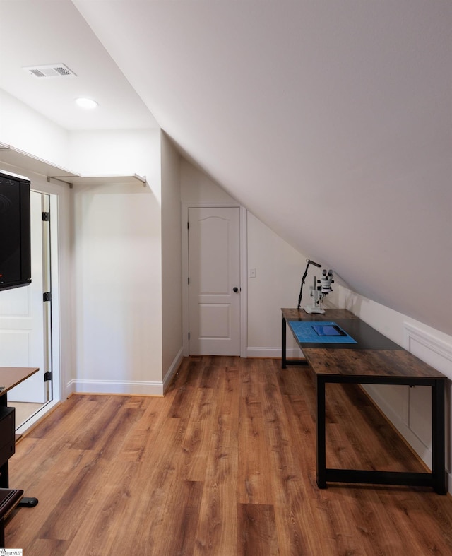 additional living space with lofted ceiling, baseboards, light wood-style flooring, and visible vents