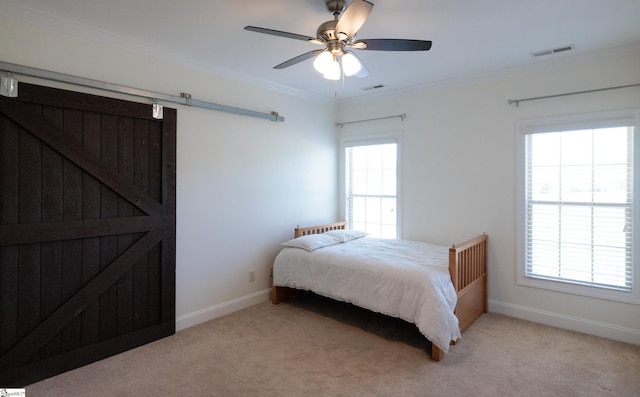 bedroom with light colored carpet, a barn door, crown molding, and visible vents