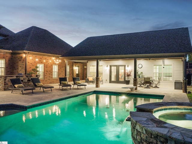 view of pool with a patio area, french doors, and a pool with connected hot tub