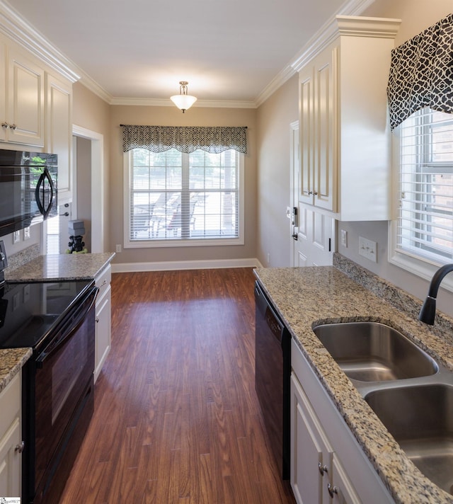 kitchen with a sink, dark wood-type flooring, black appliances, and crown molding
