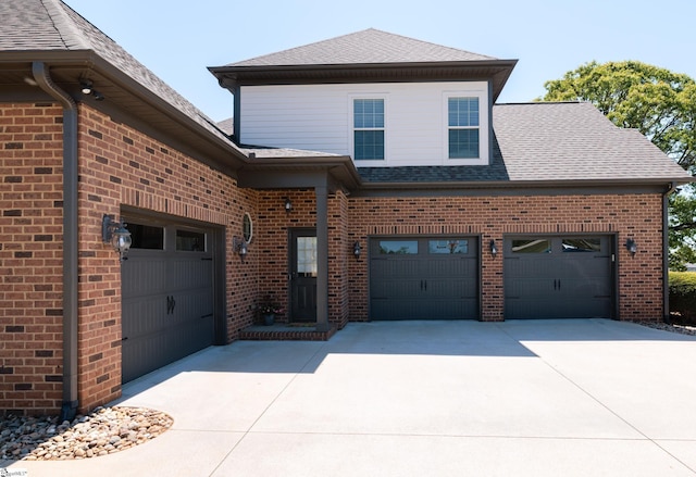 view of front of property featuring driveway, roof with shingles, and brick siding