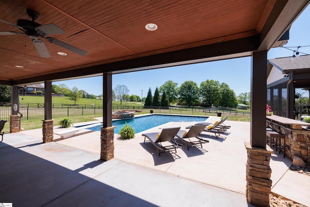 view of pool with ceiling fan, a fenced backyard, outdoor dry bar, a patio, and a pool with connected hot tub