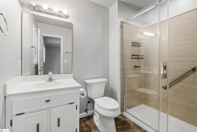bathroom featuring baseboards, vanity, toilet, and a stall shower