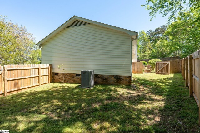 view of property exterior with a lawn, a fenced backyard, and cooling unit