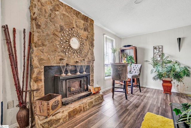 sitting room with hardwood / wood-style floors, baseboards, a textured ceiling, and crown molding
