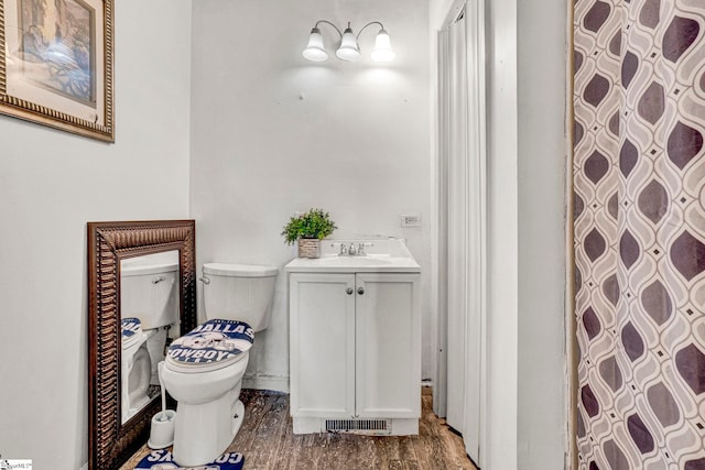 full bath featuring wood finished floors, vanity, a shower with shower curtain, and toilet
