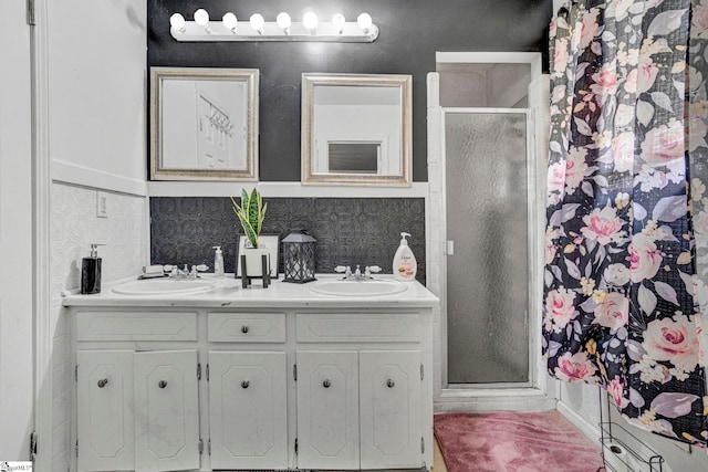 bathroom featuring a sink, a shower stall, and double vanity