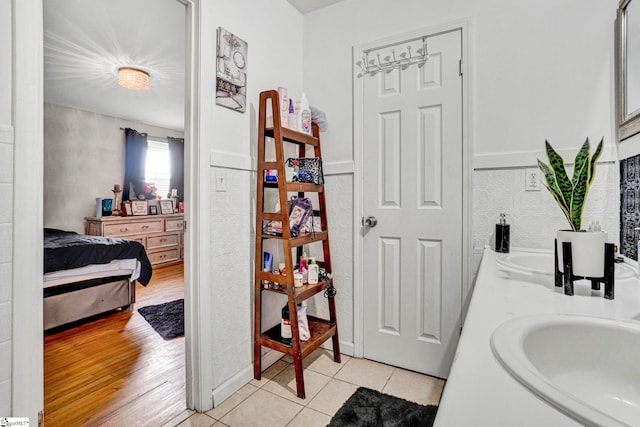 ensuite bathroom featuring tile patterned flooring, a sink, double vanity, and connected bathroom
