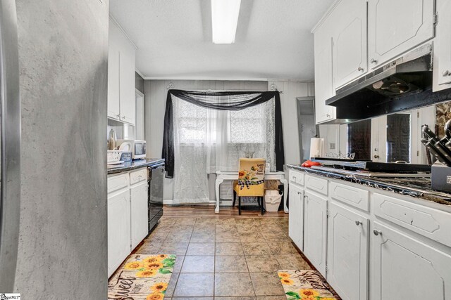 kitchen featuring white cabinets, under cabinet range hood, dark countertops, white microwave, and black dishwasher